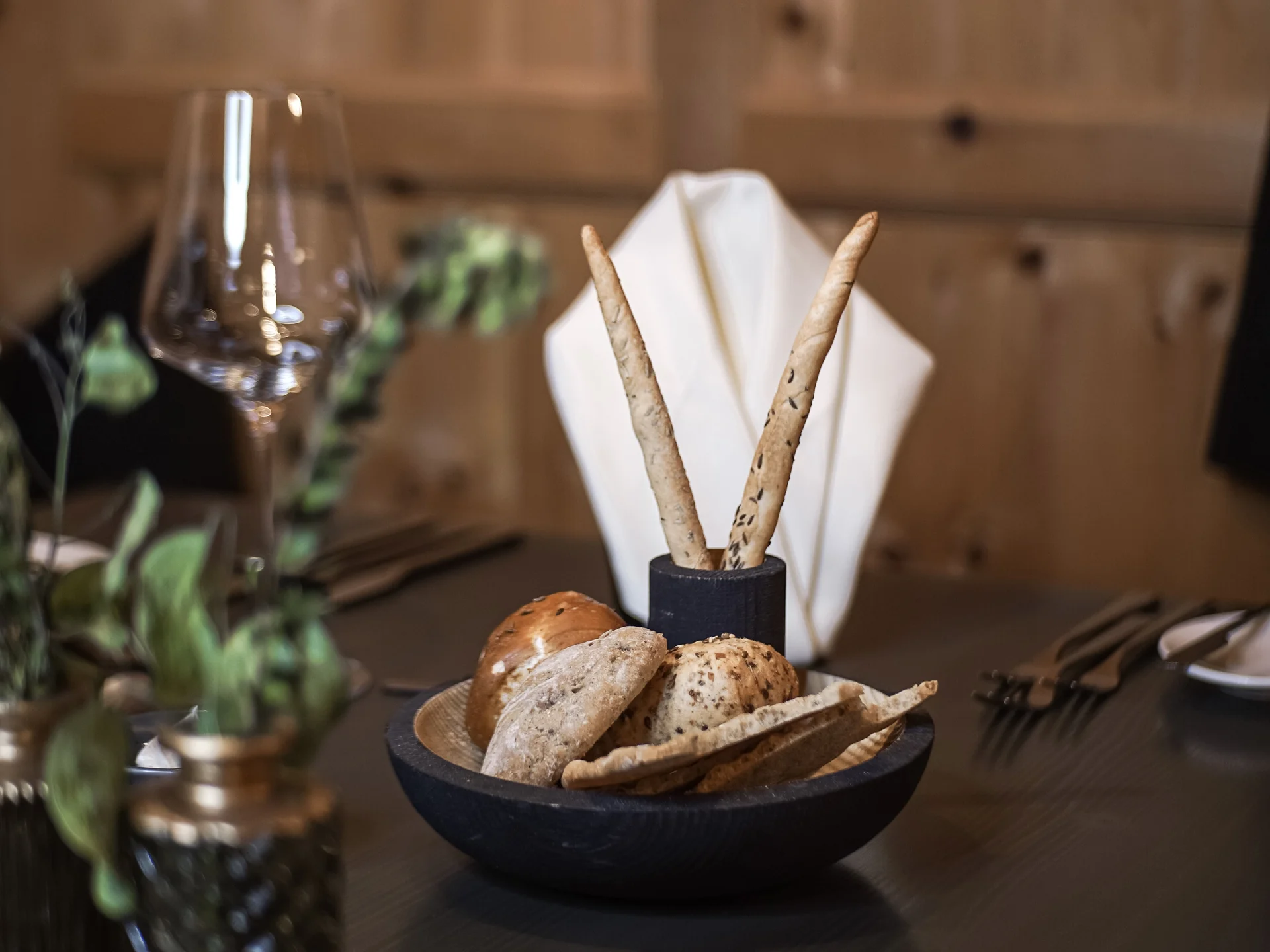 Friedrich ist DAS Boutiquehotel in den Dolomiten Verschiedene Brotsorten und Grissini auf einem gedeckten Restauranttisch